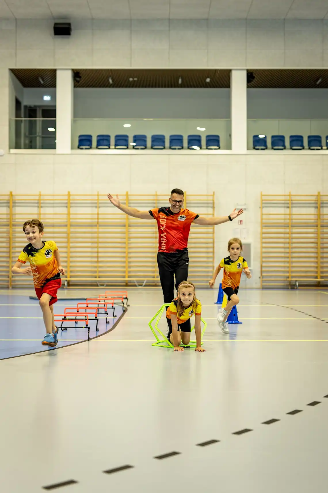 Wychowawca dopingujący podczas wyścigu dzieci w Ninja Kids Academy